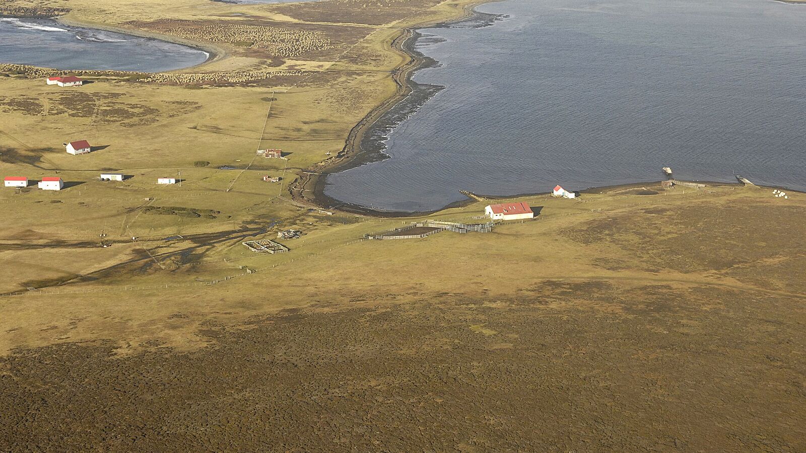 Luchtfoto van de kleine settlement op Bleaker Island op een smalle landengte tussen twee baaien