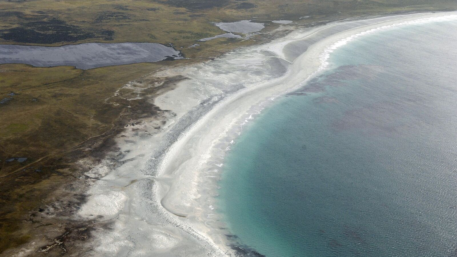 Luchtfoto van het lange witte strand van Sandy Bay met turquoise water op Bleaker Island