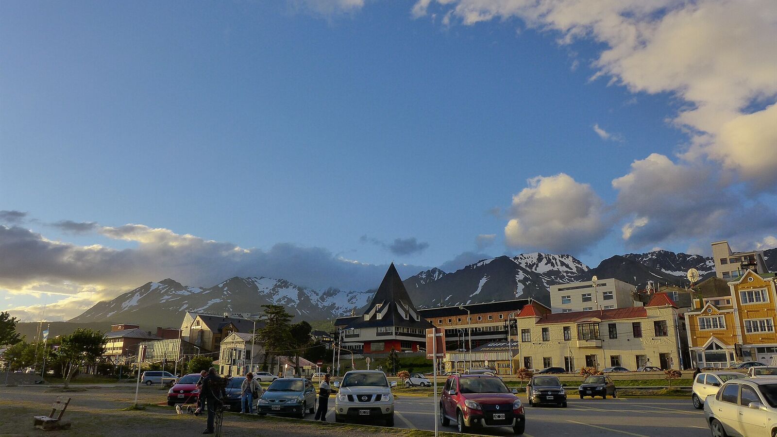 Straat in het centrum van Ushuaia met gekleurde gebouwen en besneeuwde bergen op de achtergrond